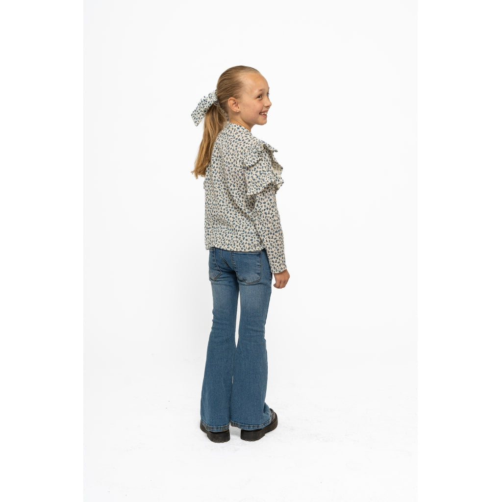 Flared jeans fra The New i blå vask, med utsvingte ben – sett forfra