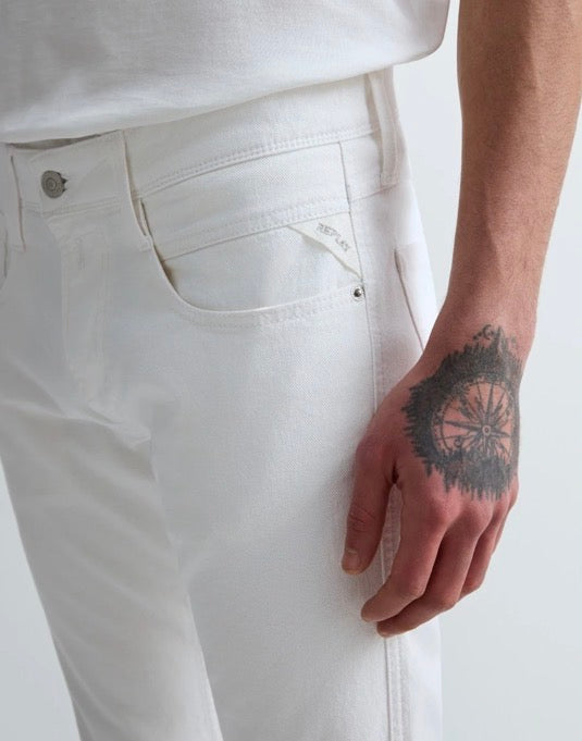 Nærbilde av frontlommen, knappen og Replay-detaljen på hvite Anbass-jeans.