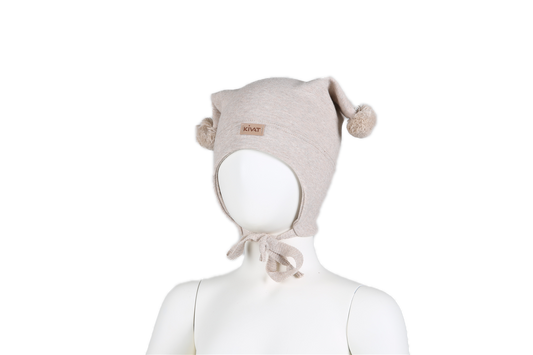 Beige Kivat-lue med beige dusker, vindtett stoff og brun logo.