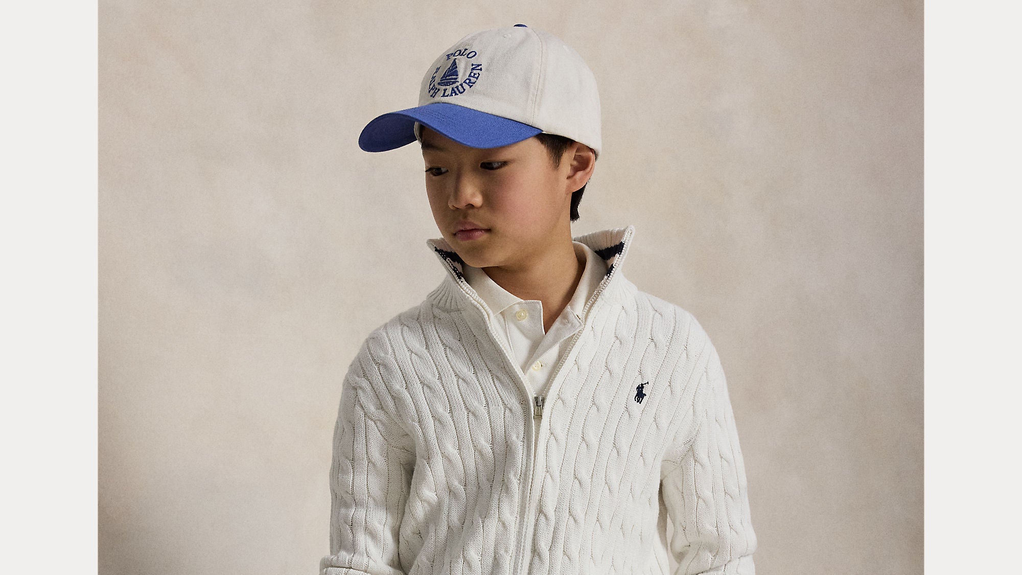 Gutt i hvit Ralph Lauren-genser og caps – skole- og barnehagestart